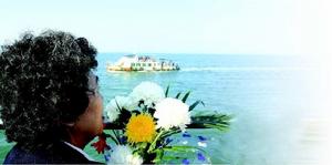 在青岛参加免费海葬仪式的一位市民手捧鲜花悼念亲人